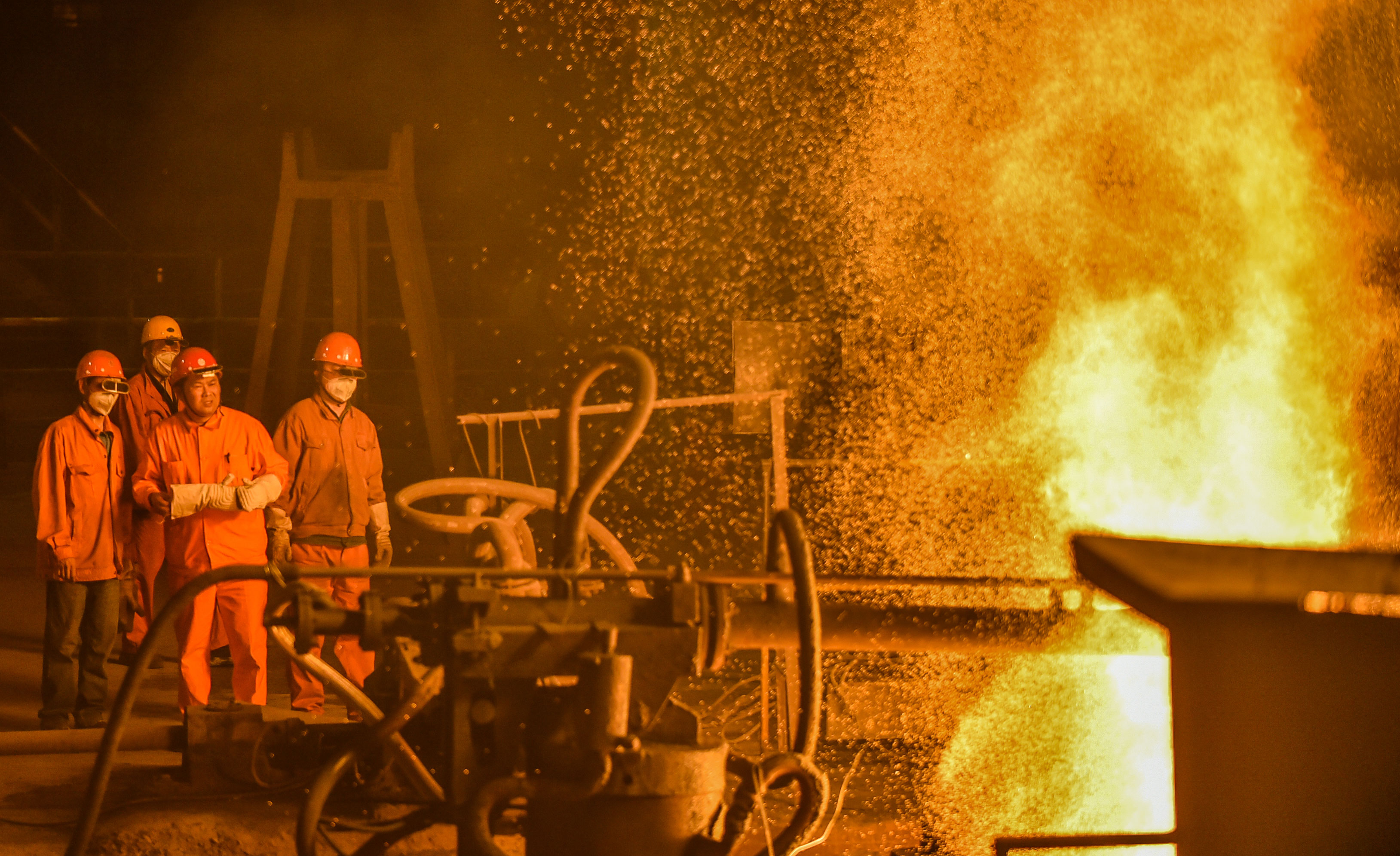 -晚11点，杨金安（右二-）班组成员要在高温炉-前时刻监测炼钢进程。.jpg